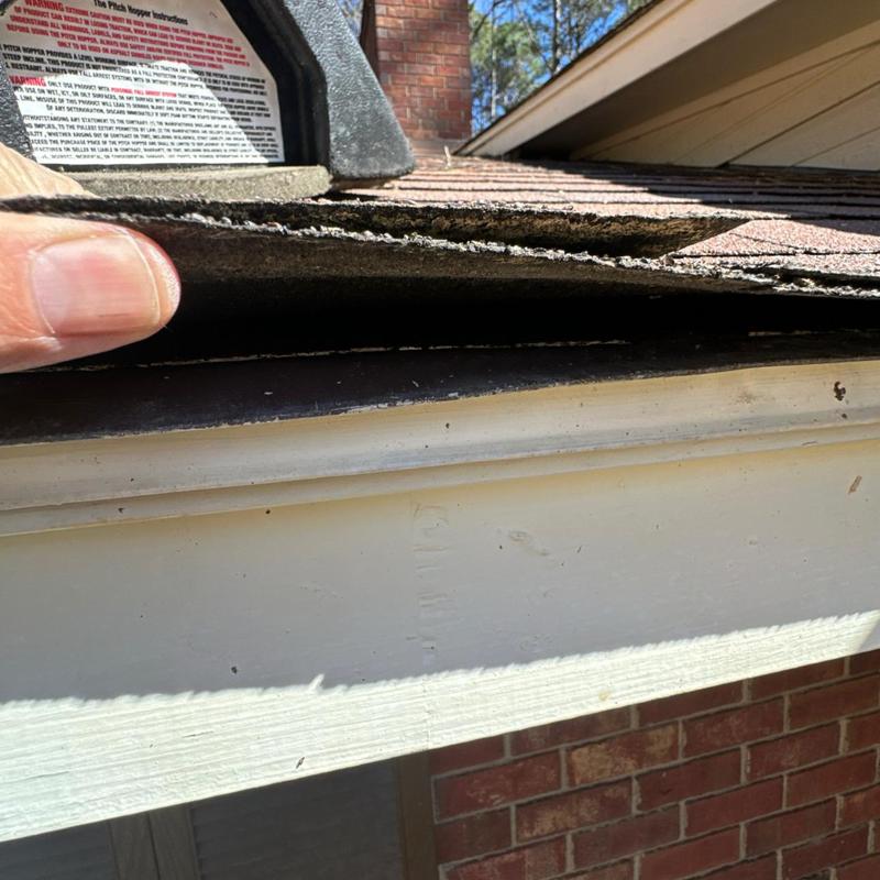 Roof shingles lifting near roof edge and gutter trim