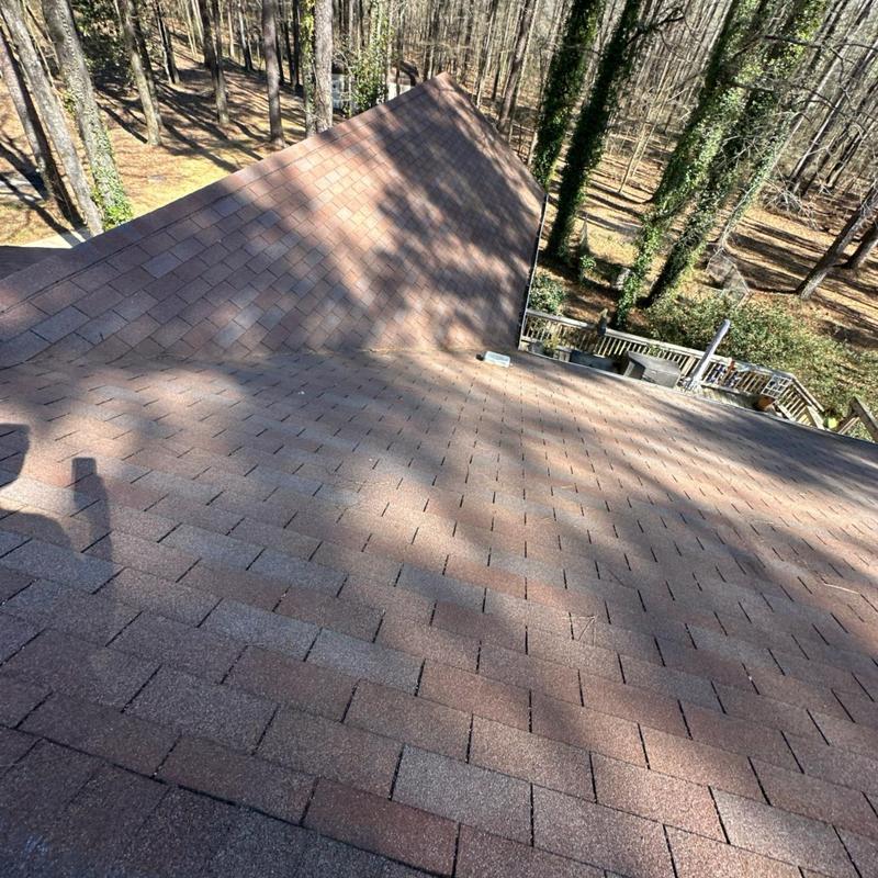 Asphalt shingle roof inspection on wooded residential property