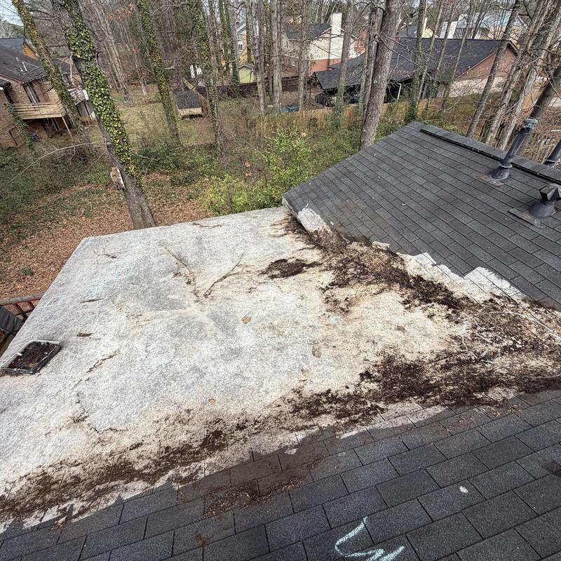 Rolled roofing with debris and surface damage on flat roof