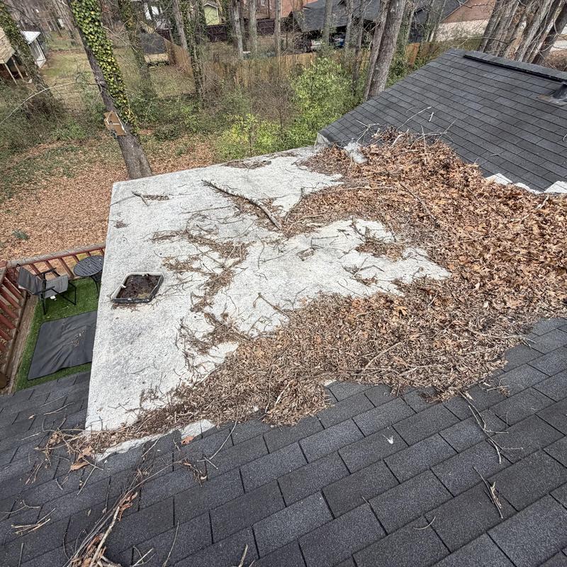 Rolled roofing with debris on flat roof section