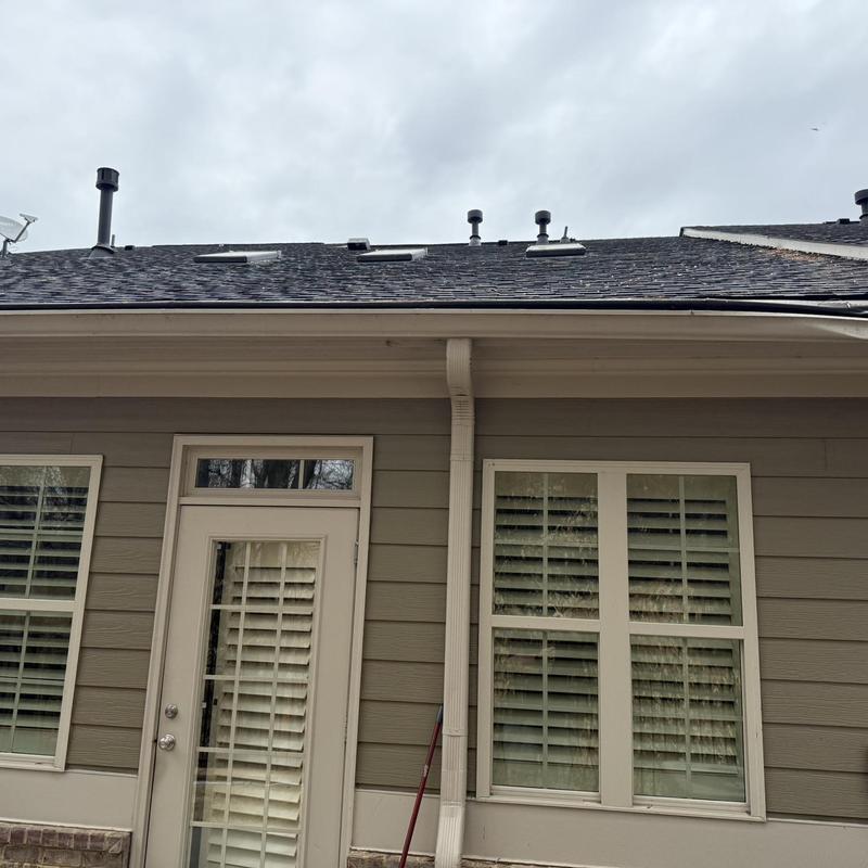 Seamless aluminum gutters with guards on house exterior
