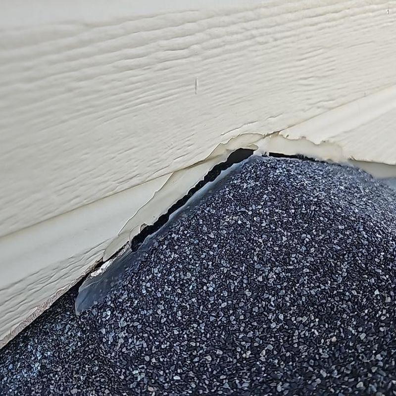 Step flashing on shingle roof edge with siding damage Step flashing on shingle roof edge with siding damage