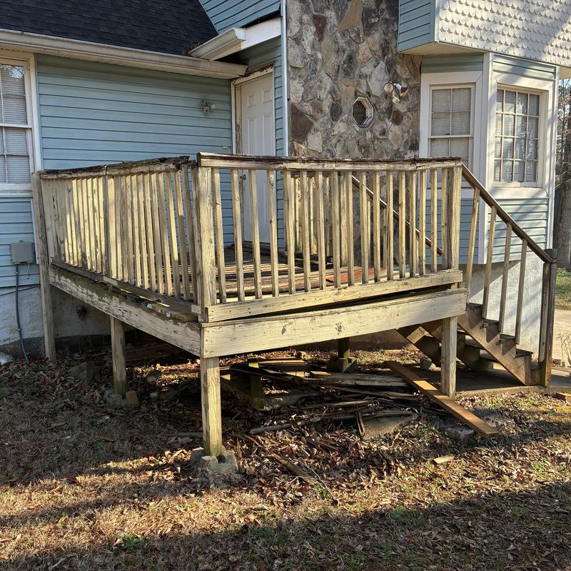 Wooden deck with railings and stairs on blue house