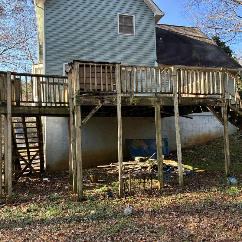 Wooden deck with railings and stairs, weathered condition