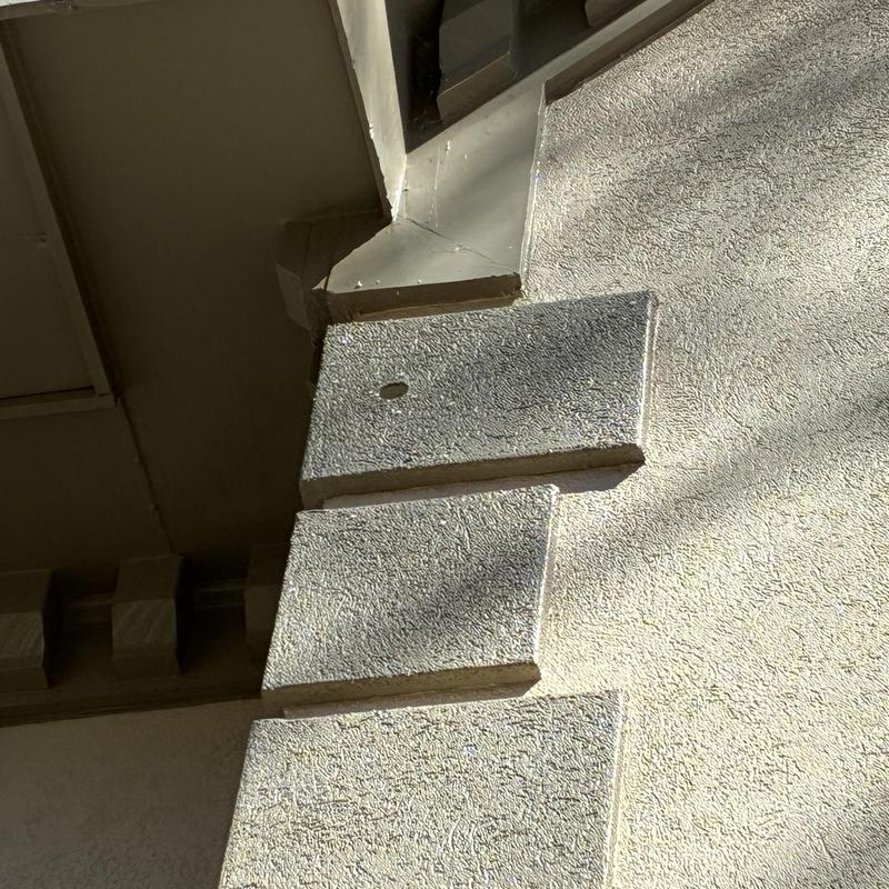 Stucco exterior wall with small bird damage hole