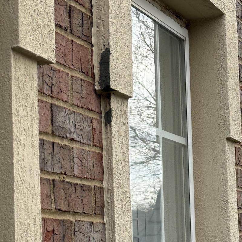 Stucco cracks and holes around window frame exterior