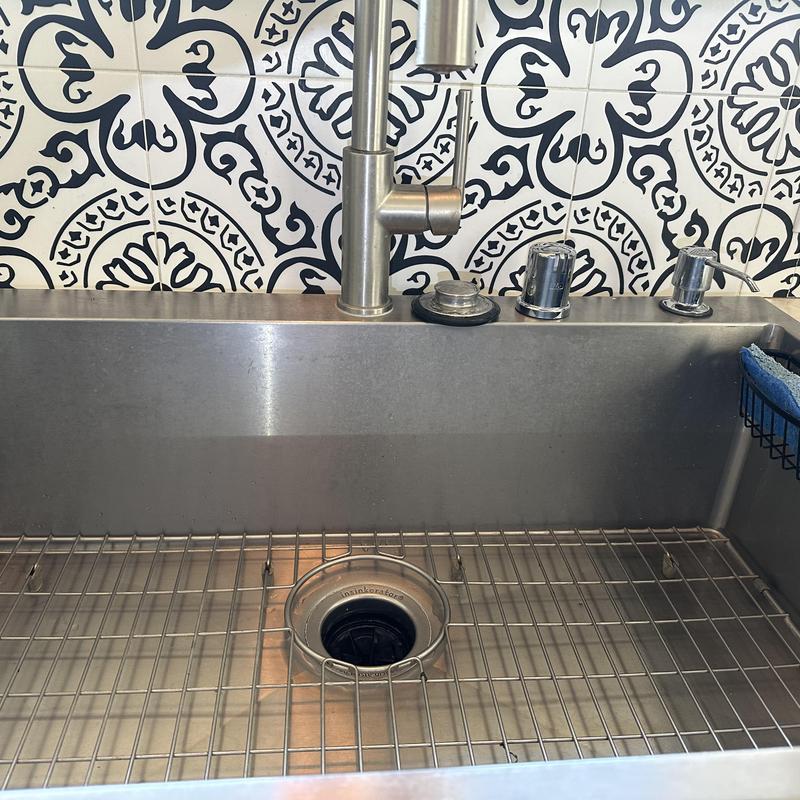 Stainless steel kitchen sink with modern faucet and soap dispenser