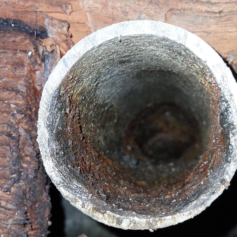 Copper drain pipe interior showing corrosion buildup