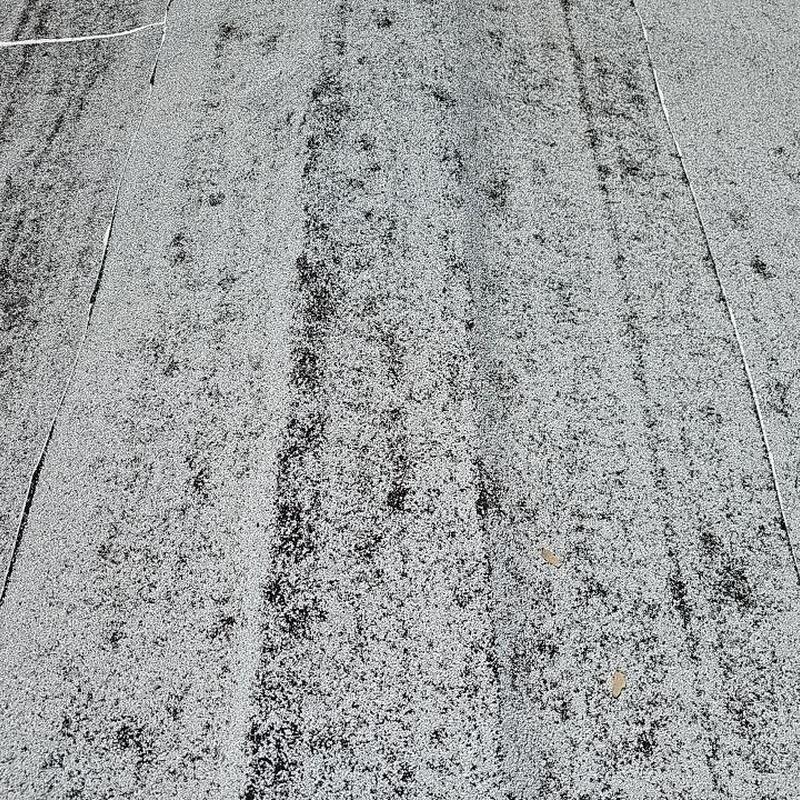 Flat roof surface with hail damage and discoloration Flat roof surface with hail damage and discoloration