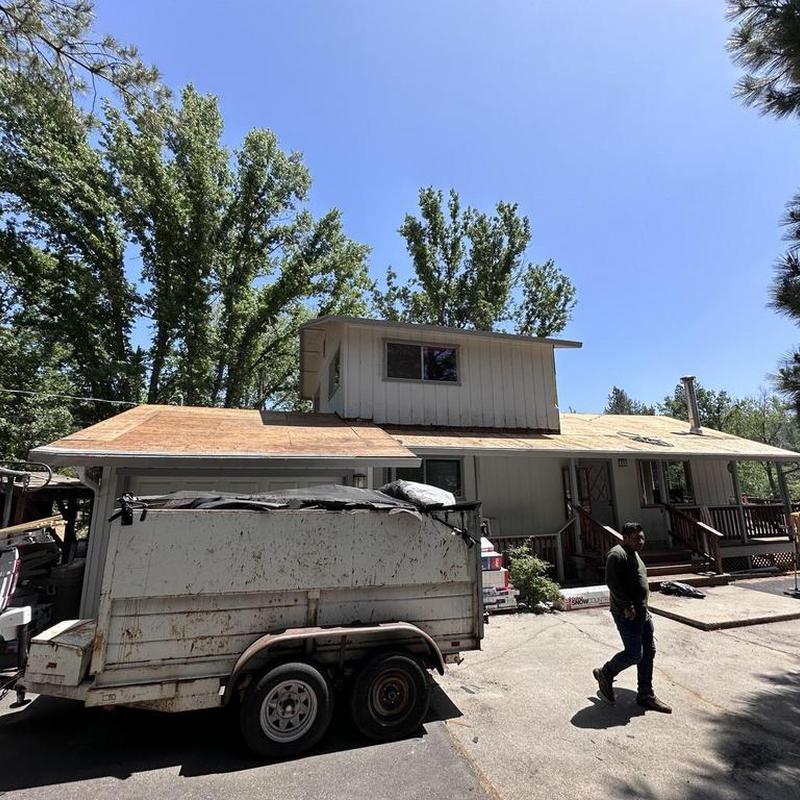 Asphalt roof decking replacement with trailer in driveway