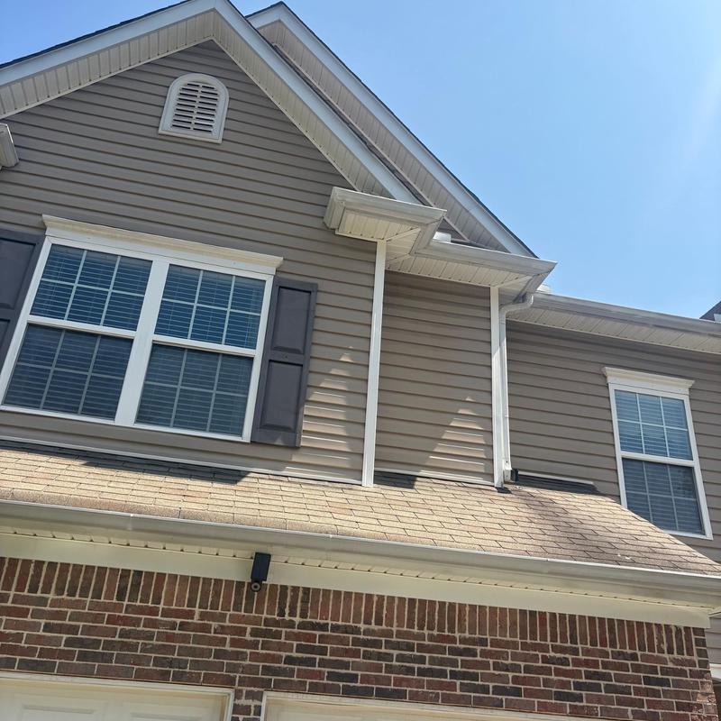 Asphalt shingle roof with gutter and siding above garage
