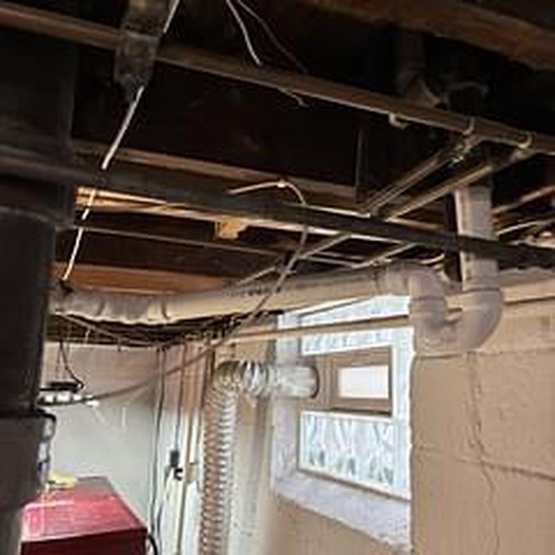 Bathtub drain PVC trap and pipe installation in basement