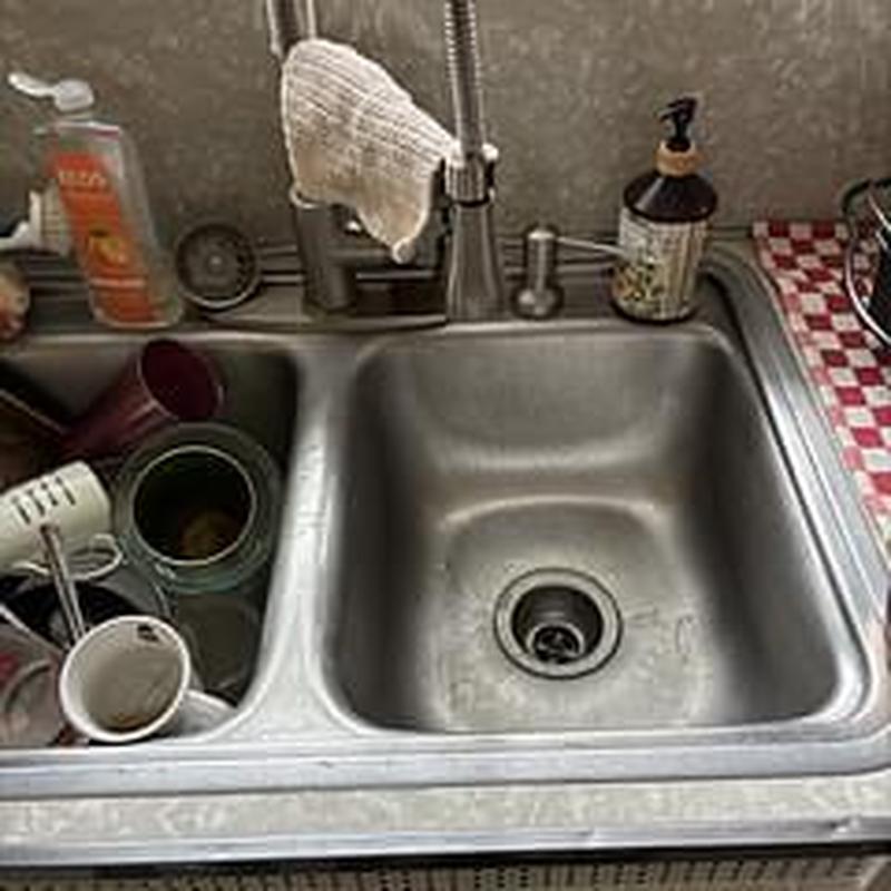 Kitchen sink drain with faucet and dishware nearby
