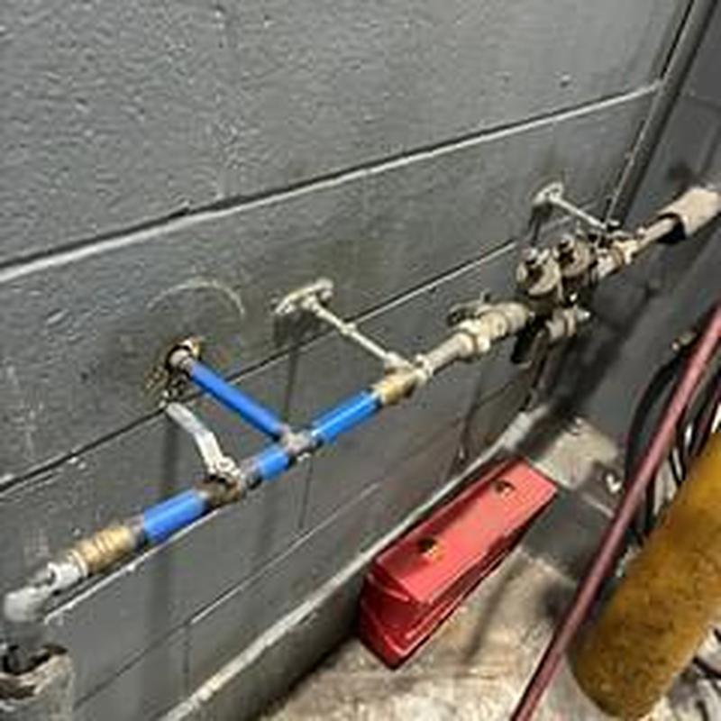 Blue water supply pipe with repaired section on wall