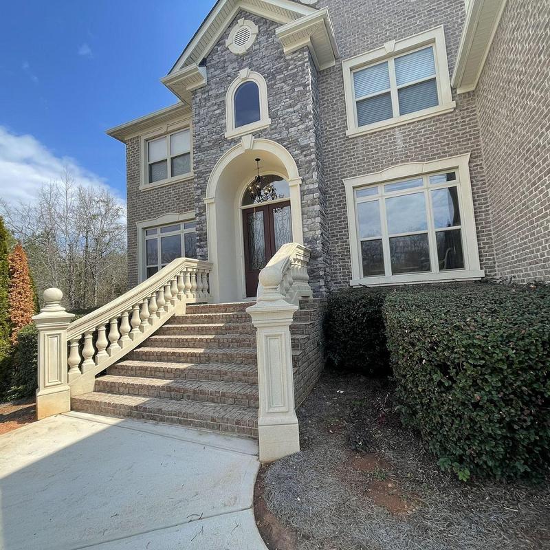 Stone entry stairs with balustrade and brick facade