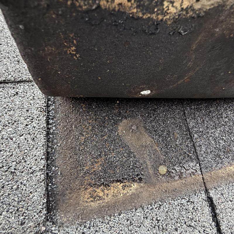 Roof shingles with deteriorated sealant and nail head visible