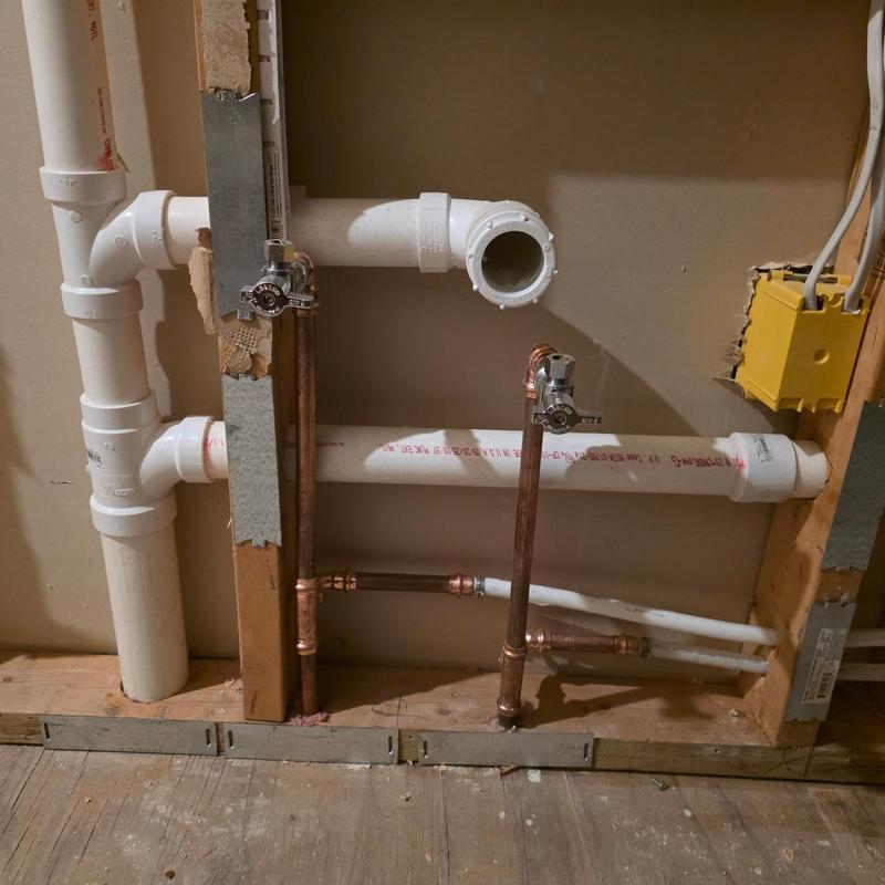 Copper water lines and PVC drains installation in wall cavity