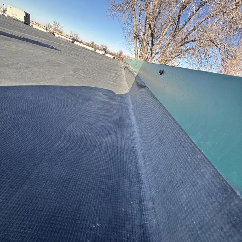 Commercial EPDM roof corner with metal flashing in Midvale