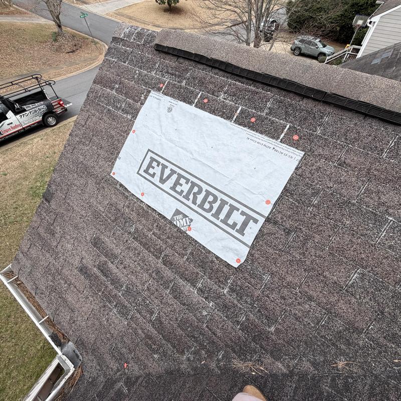 Roof shingles with tarp over leak on residential roof