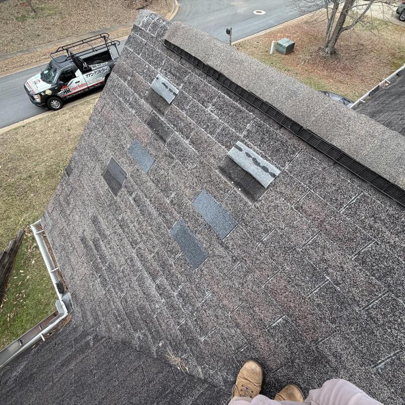 Worn 3-tab shingle roof with missing patches and tarp