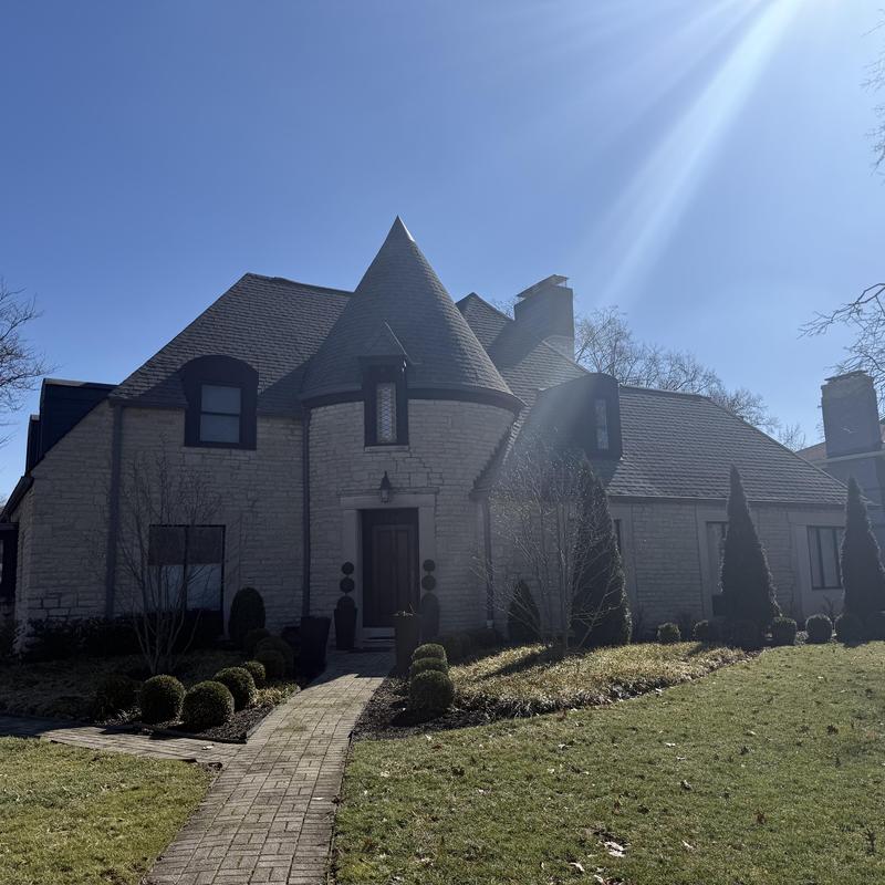 Asphalt shingle roof on stone house with landscaping Asphalt shingle roof on stone house with landscaping