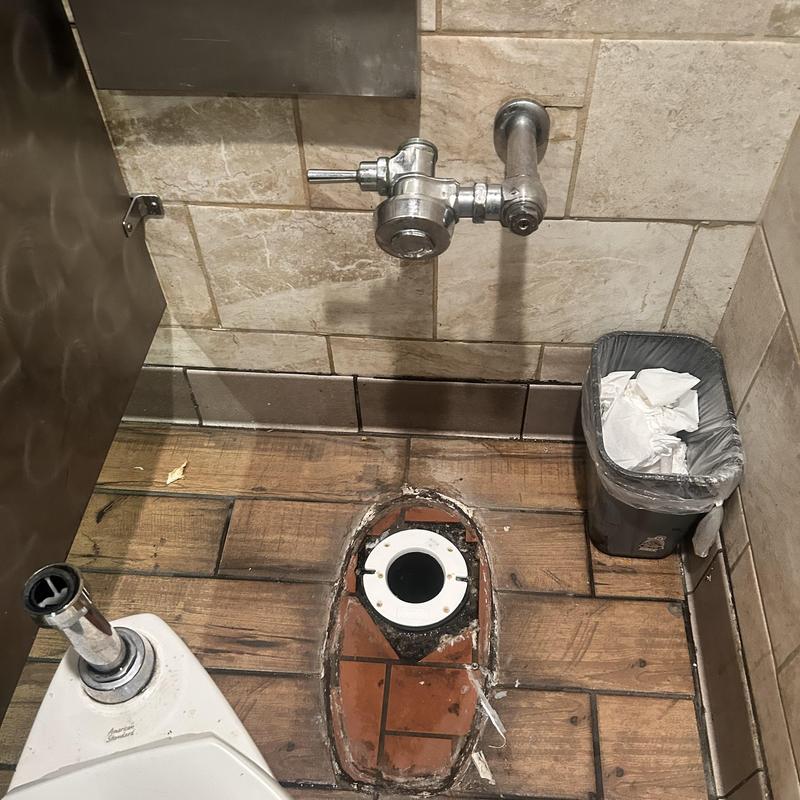 Closet flange and Sloan valve in restaurant restroom