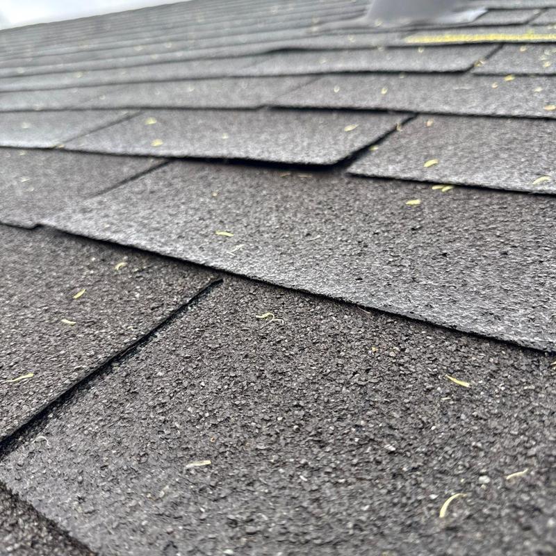 Asphalt shingle roof with hail damage and lifting edges