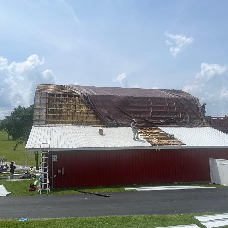 Metal roof panel removal and tarp covering on barn roof