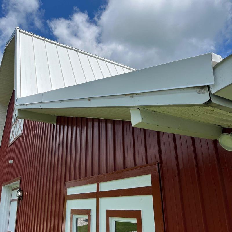 Metal roof edge flashing on red barn exterior
