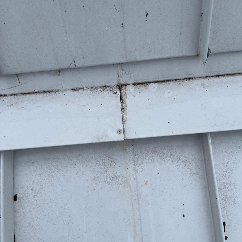 Metal roof panel seam with signs of wear and corrosion