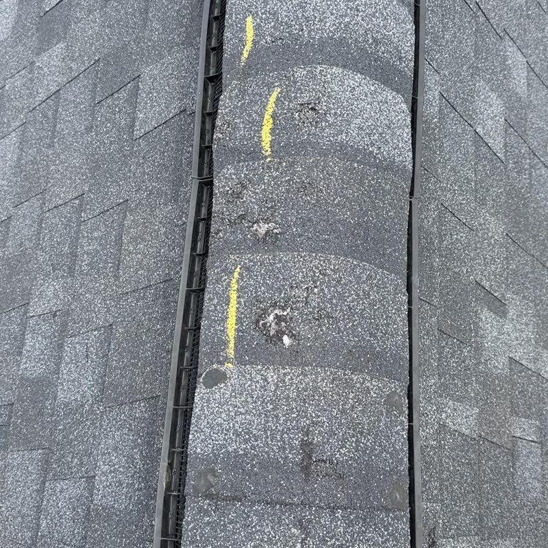 Roof shingles with marked hail damage and granule loss