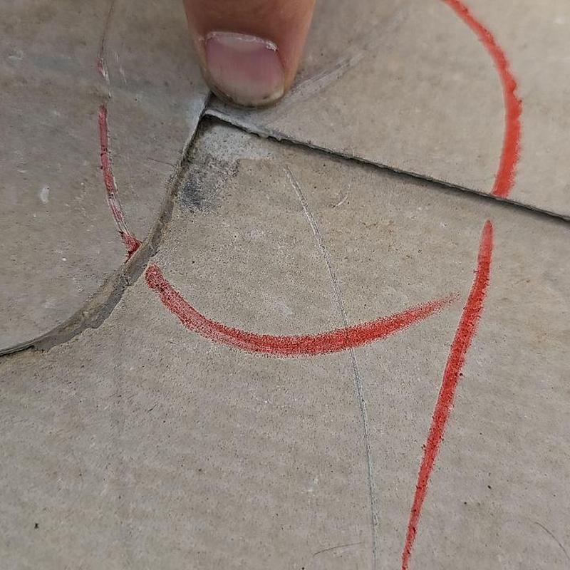 Concrete floor crack with red chalk markings and finger Concrete floor crack with red chalk markings and finger