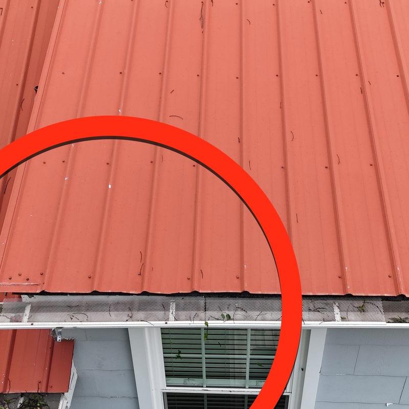 Metal roofing panels with hail damage near flashing
