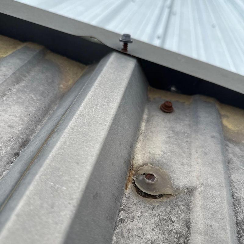 Metal roof panel with damaged fastener and sealant