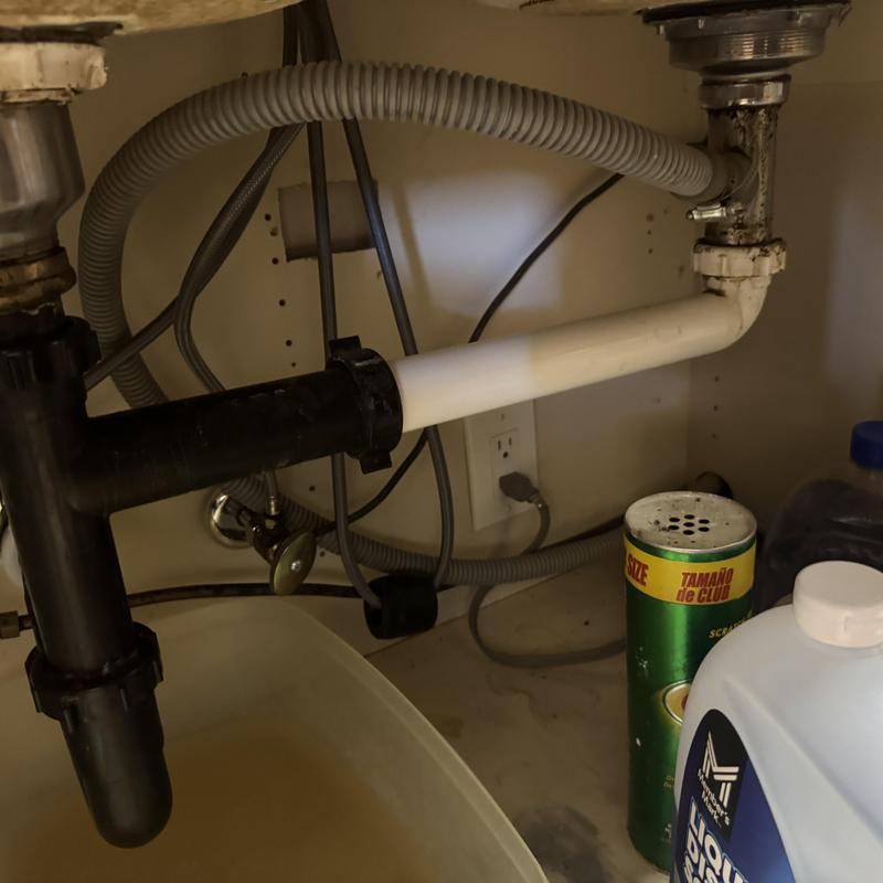 Kitchen sink drain pipes and flexible hoses under cabinet