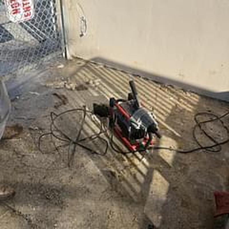 Sewer machine with cable on concrete near wall
