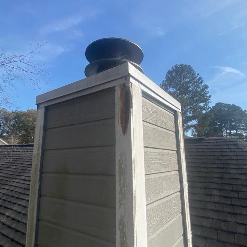 Chimney stack wood siding with water damage and rust stain