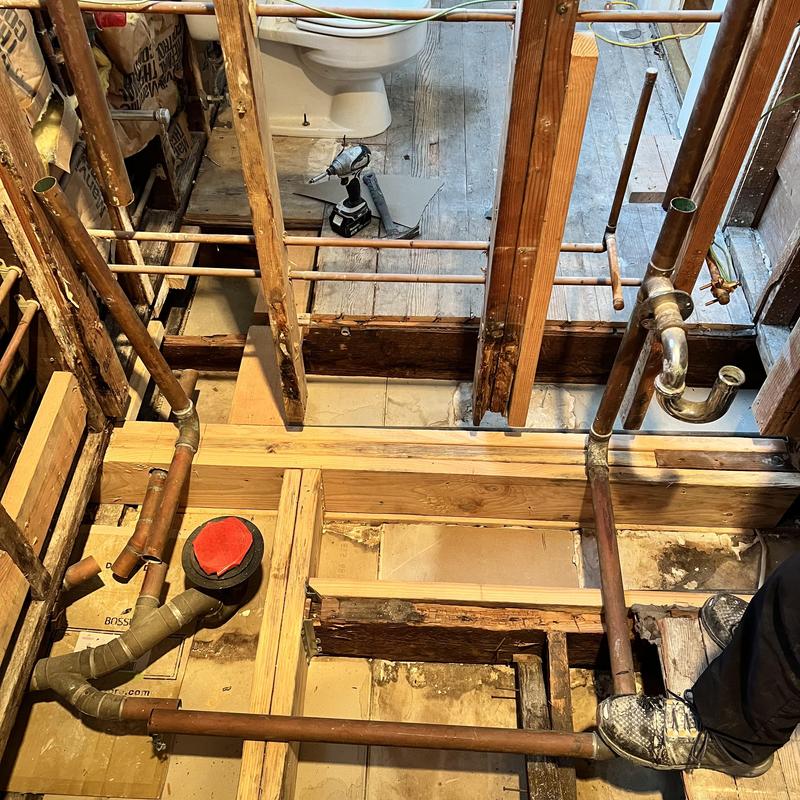 Copper drain line installation in bathroom floor framing