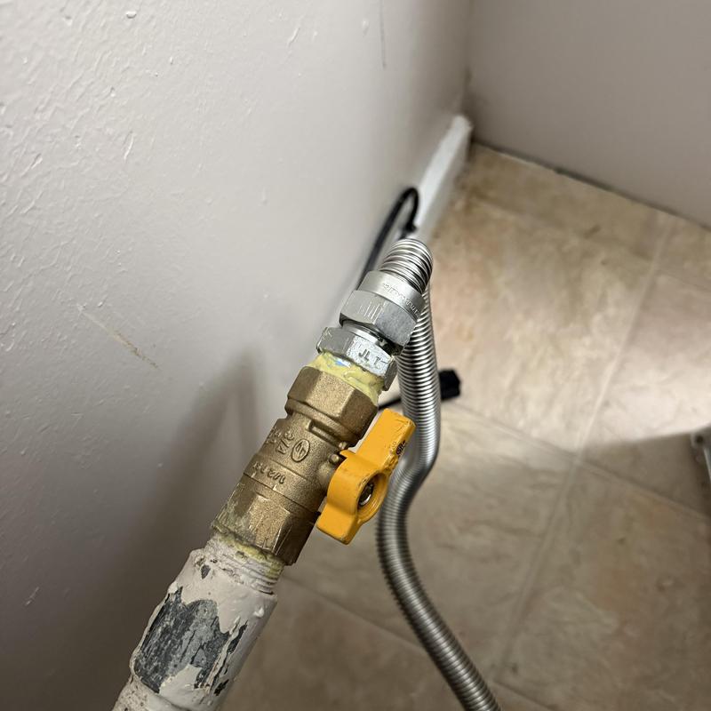 Gas valve with yellow handle and flexible hose connection