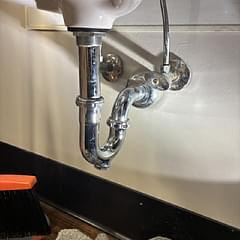 Hand sink P-trap and drain plumbing under basin