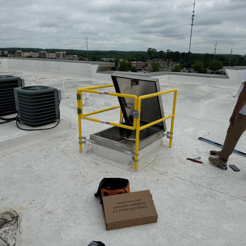 Roof hatch with safety railing on flat roof