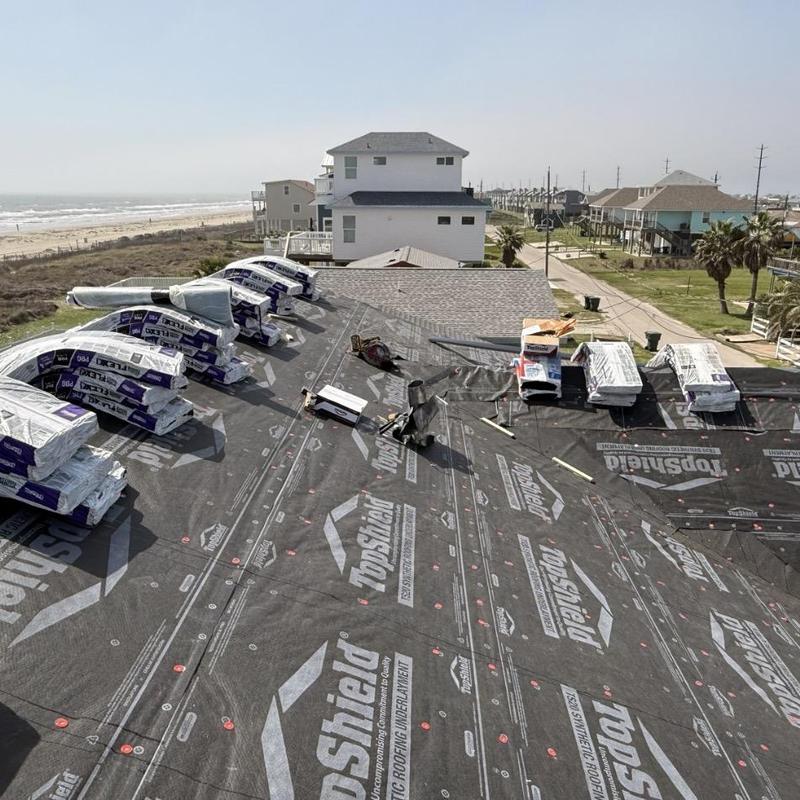 Synthetic roofing underlayment installation on coastal home roof