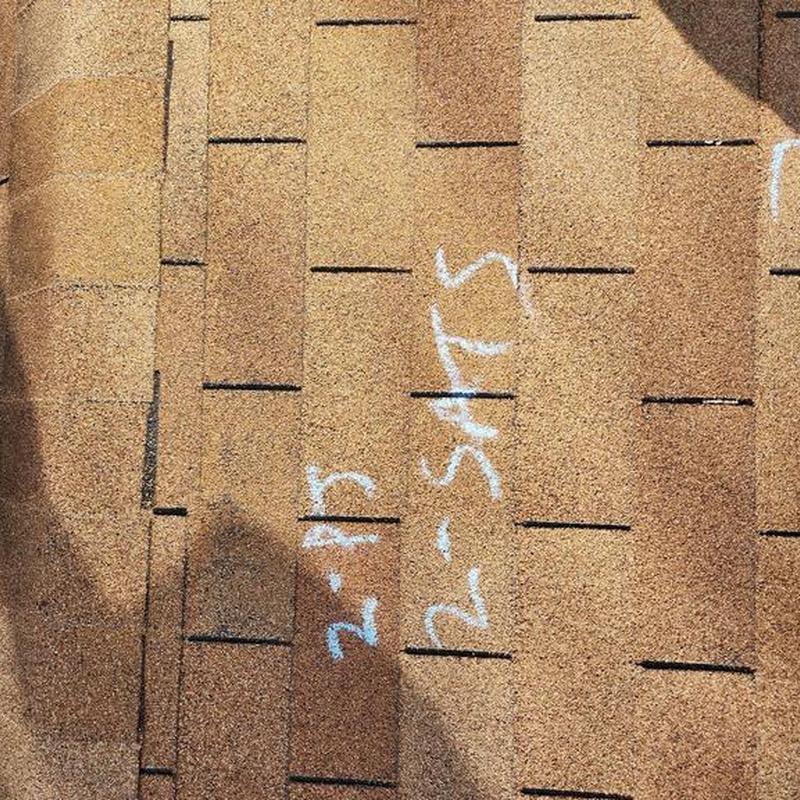 Asphalt shingle roof with chalk markings during inspection
