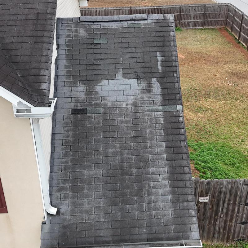 Roof shingles with damaged and missing pieces, small tarp installed