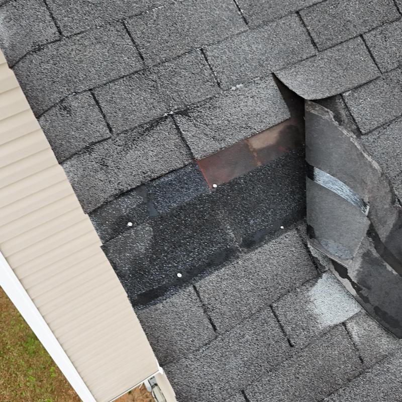 Faded slate roof shingles with visible damage and repairs
