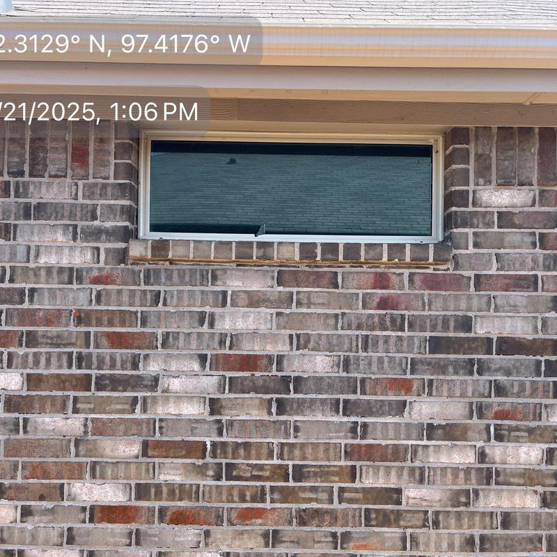 Storm-damaged narrow basement window repair in brick wall