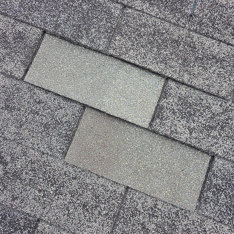 Asphalt roof shingles with two replaced sections