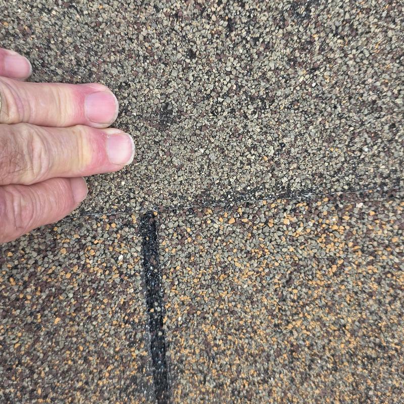 Roof shingles close-up showing hail damage and granule loss