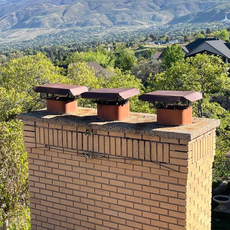 Chimney caps with rust and debris buildup outdoors