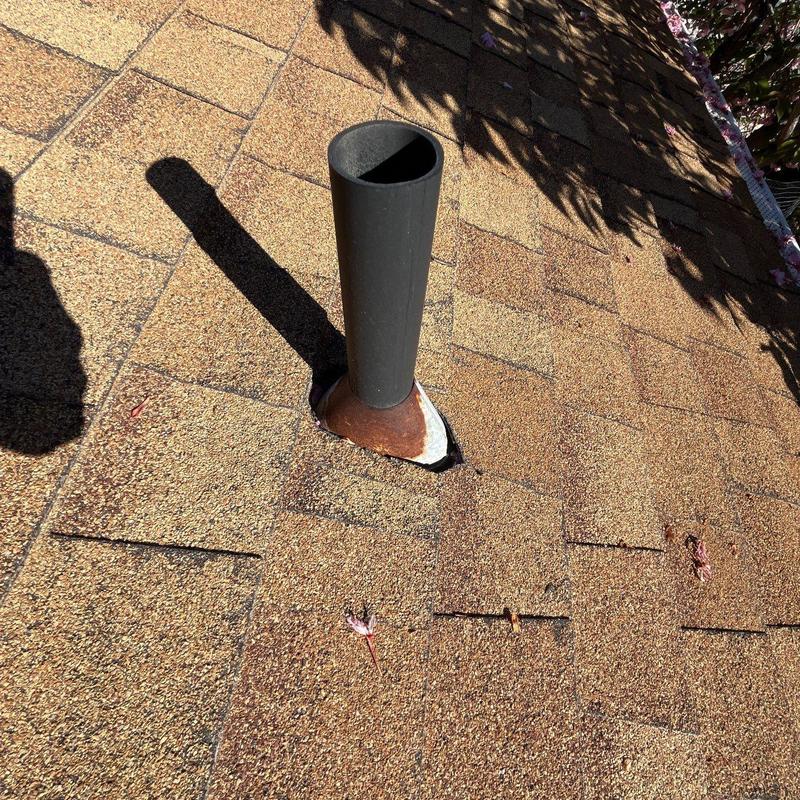 Roof pipe flashing on asphalt shingle roof with damage